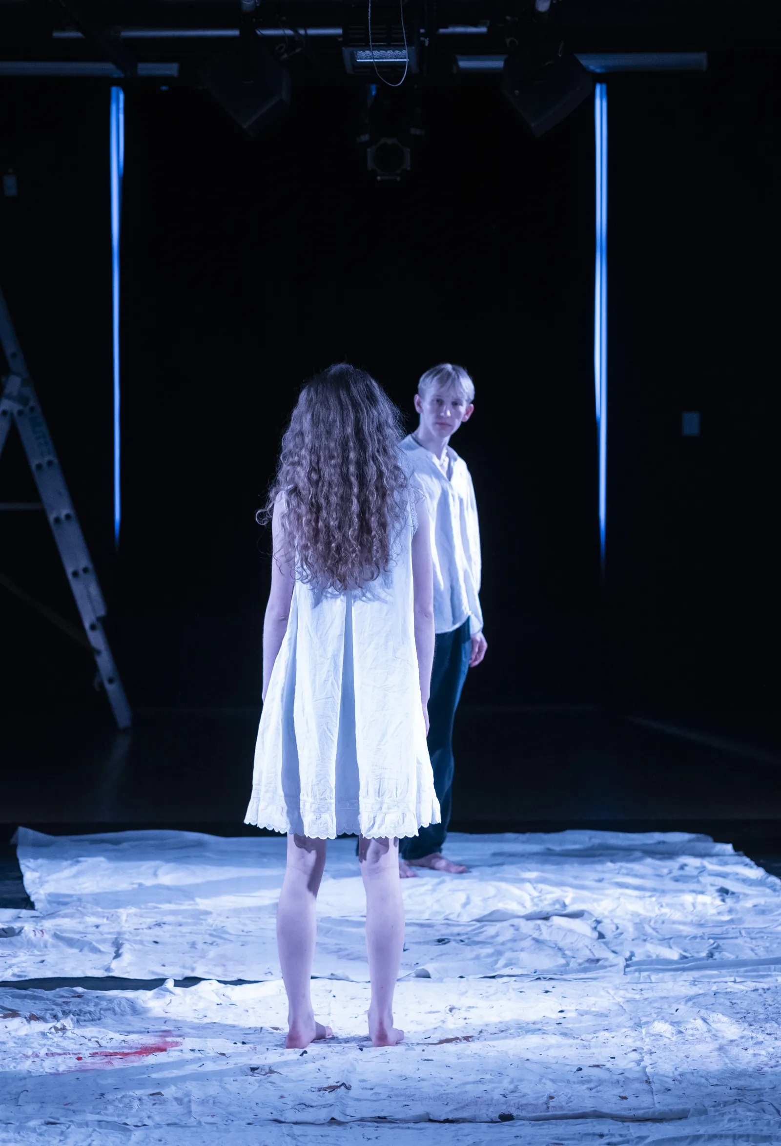 Eurydice with her back to the audience, facing her father.