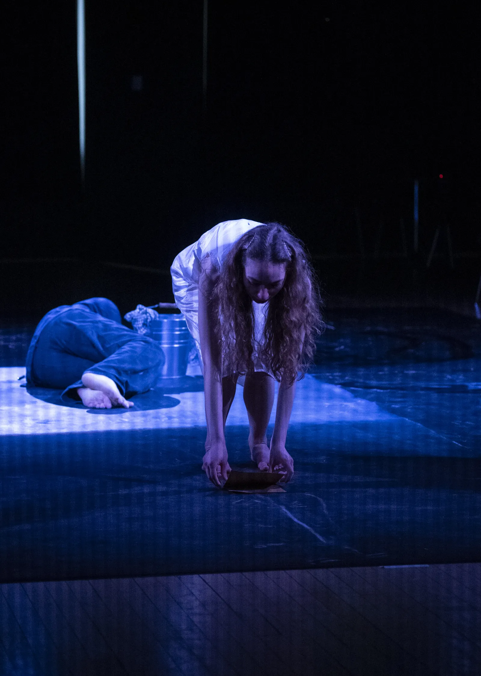 Eurydice crawling forward with a figure curled behind her.